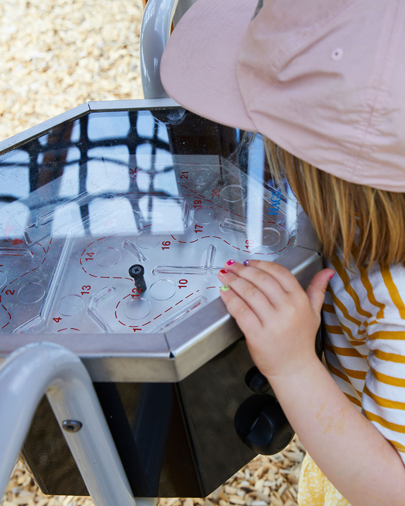 Labyrinth auf dem Spielplatz, mit dem ein kleines Kind spielt. Wir können ihr Gesicht nicht sehen.